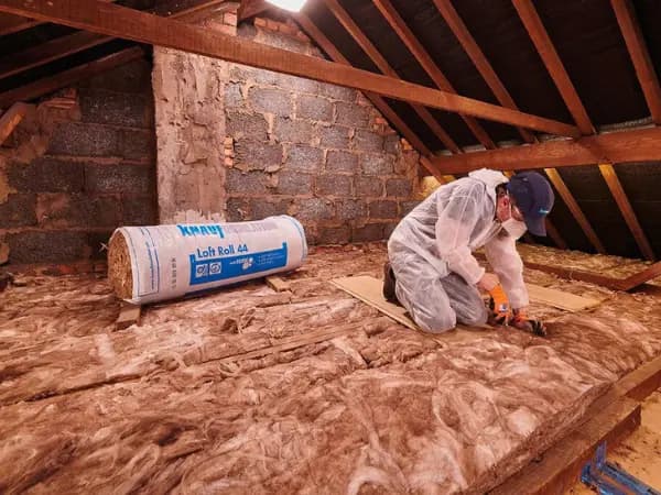Loft insulation being installed in a Scottish home to reduce heat loss